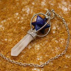Clear quartz Merkaba star pendulum pendant with silver-tone chain on textured background