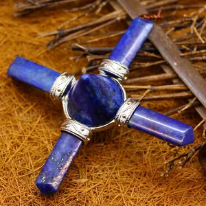 Blue lapis lazuli crystal pyramid with four energy wands on natural straw background.