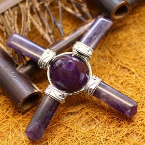 Natural amethyst crystal pyramid ornament with silver metal accents on rustic background
