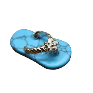 Magnifique pendentif en turquoise en forme de tong pour femme avec fleur argentée.