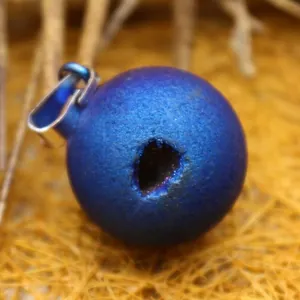 Blue druzy agate egg pendant with natural opening on straw nest background
