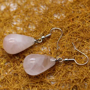 Elegant pink crystal teardrop earrings with silver fishhooks on gold straw backdrop