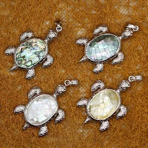 Cuatro colgantes de tortuga con incrustaciones de nácar sobre fondo de paja natural