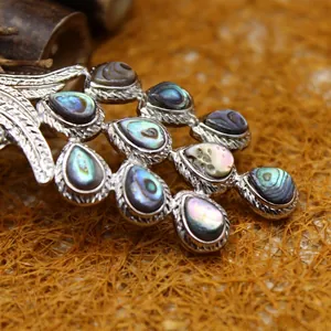 Pendentif queue de paon détaillé avec incrustations de nacre d'abalone et finition argent