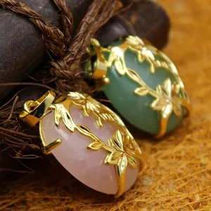 Ethnic style crystal pendants with gold floral filigree overlays on rustic background