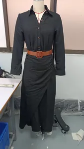 Black long-sleeved shirt dress with draped wrap skirt and brown belt on mannequin