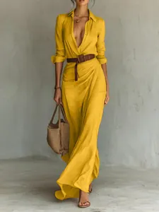 Elegant yellow long sleeve maxi dress with pleated wrap design and brown belt detail