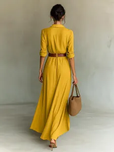 Back view of an elegant long-sleeved yellow maxi shirt dress with brown waist belt