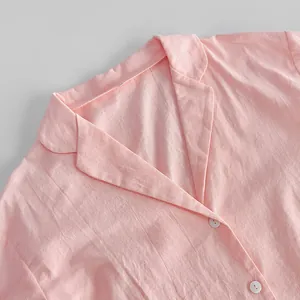 Close-up detail of the notched lapel and white buttons on a pink cotton pajama top.
