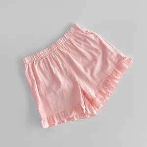 Close-up of pink cotton shorts featuring a sweet ruffled hem and elastic waist.