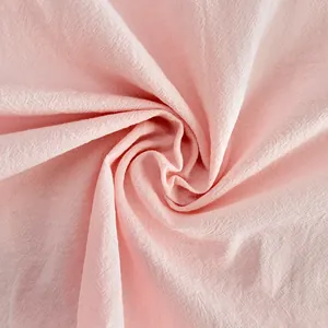 Detailed macro shot of soft pink pure cotton fabric texture showing fine weave patterns