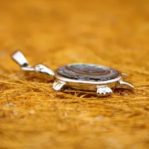 Eleganter Schildkrötenanhänger mit buntem Seeohrenschalen-Inlay auf Strohgrund