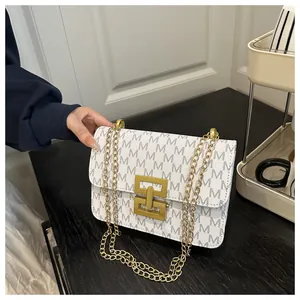 Close-up view of a stylish printed square bag with an elegant gold chain strap