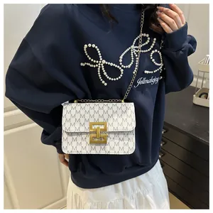 Close-up of a chic vintage print small square crossbody bag with elegant golden chain strap