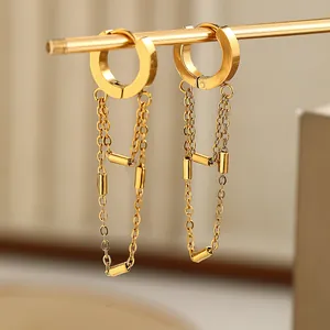 Detail view of gold stainless steel tassel chain earrings with cylindrical accents.