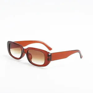 Detailed side view of trendy small square sunglasses with amber frames and brown gradient lenses