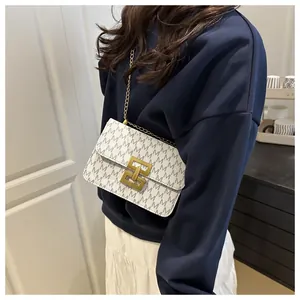 Detailed view of a stylish white printed square crossbody bag with an elegant gold chain strap