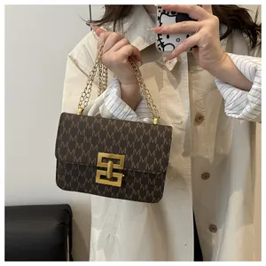 Detail of vintage printed crossbody bag with elegant gold chain and clasp for women