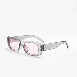 Close-up side view of grey translucent rectangular sunglasses with pink tinted lenses