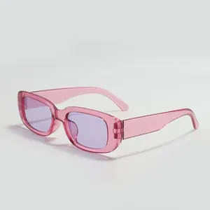 Close-up of trendy pink rectangular sunglasses with purple lenses and transparent frames