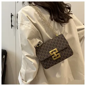Detail of retro printed flap crossbody bag with gold chain and geometric clasp