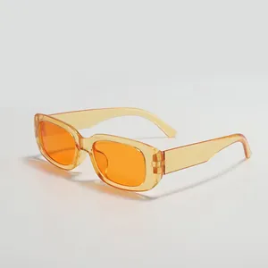 Detailed side view of trendy small square sunglasses with translucent orange frames.
