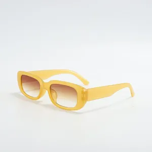 Detailed view of trendy yellow small frame square sunglasses with brown gradient lenses