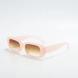 Macro detail of retro square sunglasses featuring pink frames and brown gradient lenses