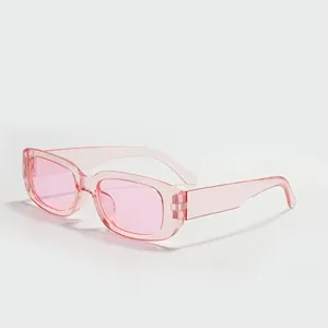Close-up of trendy square sunglasses with pink translucent frame and lenses for street style.