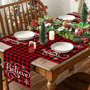 Detail des weihnachtlichen rot-schwarzen Tischläufer-Sets mit Believe-Schriftzug im Karo-Stil