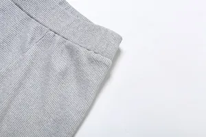 Primo piano del tessuto a costine grigio e della fascia elastica degli shorts a vita alta.
