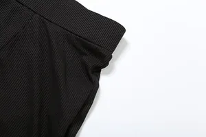 Dettaglio ravvicinato di pantaloncini neri a costine a vita alta con trama elastica