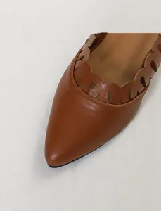 Close-up of brown soft leather pointed toe shoe with scalloped cutout detail