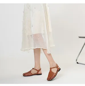 Side view of women's brown woven leather closed-toe sandals on a model