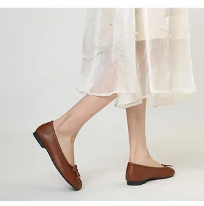 Detailed side view of brown Tabi ballet flats with split toe and bow decoration