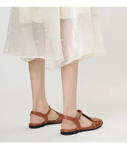 Detail of French retro hollowed-out Roman sandals on model wearing pearled dress.