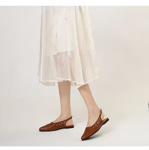 Elegant brown pointed-toe flat slingback sandals with chic laser-cut hollow details