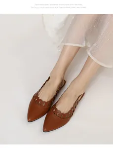 Close-up of brown pointed-toe flats with scalloped hollow detail and slingback strap
