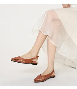 Detail view of vintage brown woven flat sandals with a stylish back strap design.