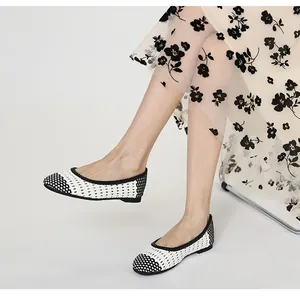 Dettaglio della trama intrecciata bianca e nera delle scarpe basse traforate retro
