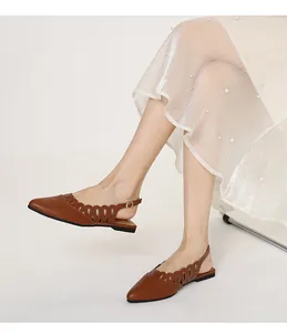 Close-up of retro brown pointed-toe slingback flats with elegant side cutout details