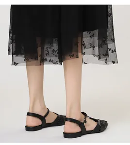 Detailed view of French retro black woven flat sandals with T-strap and bow mesh skirt