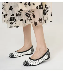 Vista dettagliata della trama intrecciata bianca e nera su eleganti scarpe basse traspiranti