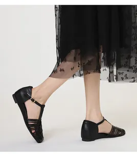Close-up view of black retro woven T-strap sandals featuring square toe and buckle
