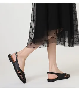 On-foot view of elegant black woven flat slingback sandals with pointed toe and hollow design