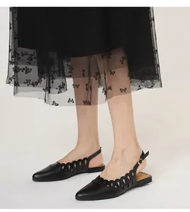 Black pointed-toe slingback flats featuring cutout scalloped edges and retro design