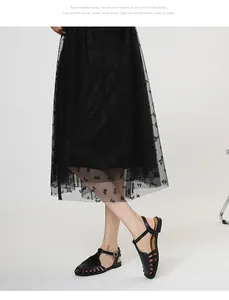 Detail shot of elegant black hollow-out closed-toe Roman sandals with T-strap on model