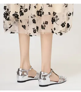 Detail shot of silver metallic woven sandals featuring a T-strap and retro square toe design