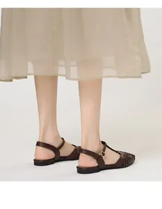 Detailed close-up of French vintage woven flat sandals with T-strap and buckle