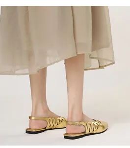 Detailed view of gold hollow-out flat sandals with elegant back strap design